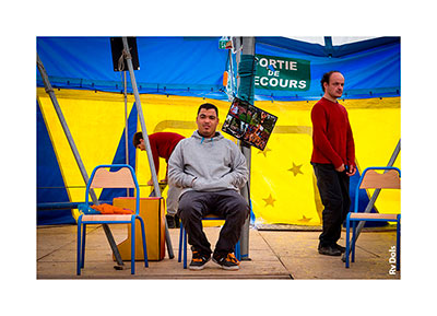 Assis sur une chaise sous le chapiteau.
