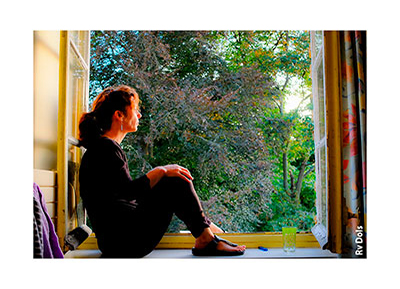Femme assise sur le rebord de la fenêtre.